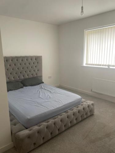 a bedroom with a large bed in a white room at Tyldesley Manor in Tyldesley