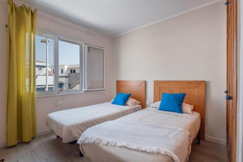 Dos camas en una habitación con dos ventanas. en Casa Melani, Sea and Relax, en Playa Honda