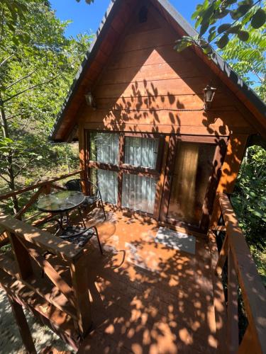 a log cabin with a table and a patio at Chateau Maxuntseti in K'veda Bzubzu