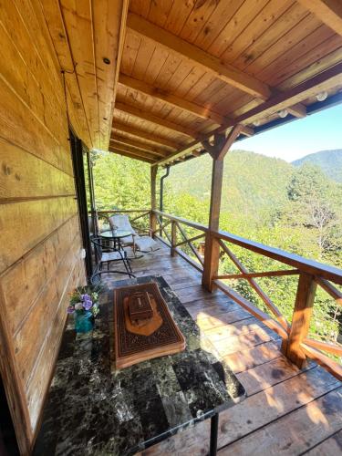 a screened in porch of a tree house with a table and chairs at Chateau Maxuntseti in K'veda Bzubzu
