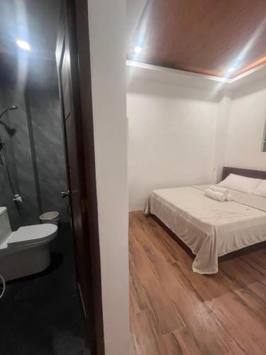 a small bedroom with a bed and a bathroom at Jezette's Inn in Sipalay