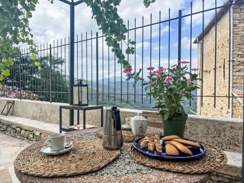 a table with a plate of bread and a vase at Holiday Home Il Collegio by Interhome in Lucinasco