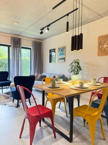 a dining room with a table and colorful chairs at Apartament w górach ze SPA in Szczyrk