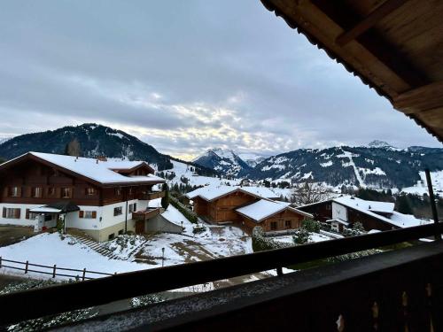 a view of a snow covered village with mountains at Gstaad Blue Sky Chalet with stunning views in Gstaad