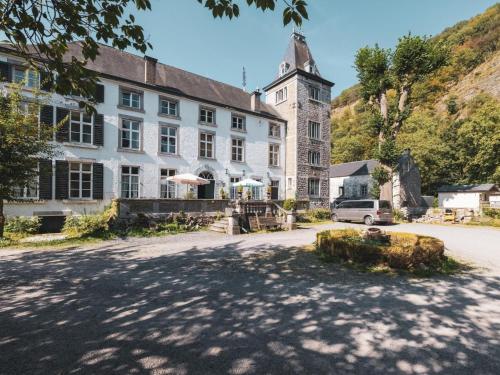 a large white building with a clock tower on a street at Cozy Apartment in a 16th Century Castle in Aywaille