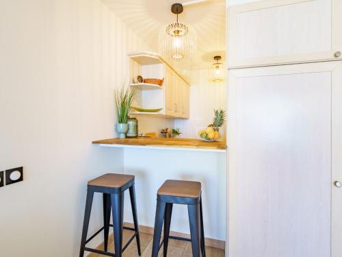 eine Küche mit zwei Hockern vor einer Theke in der Unterkunft Studio Sofitel-Miramar-2 by Interhome in Biarritz