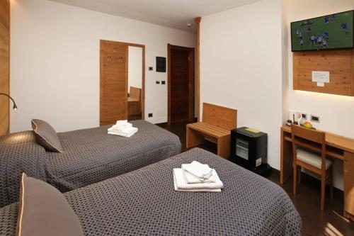a hotel room with two beds and a desk at Chalet ALLEMAND in Sauze dʼOulx