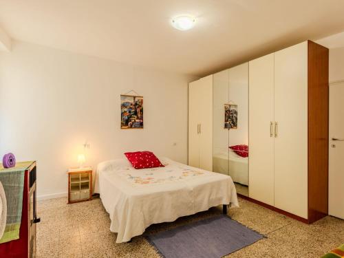 a bedroom with a bed with a red pillow on it at Apartment Sabo by Interhome in Porlezza