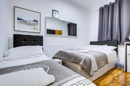 a bedroom with two beds and a mirror at Willmore Hotel in London