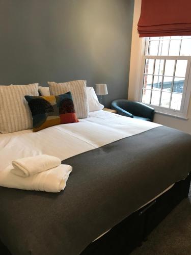 a large bed with towels on it in a bedroom at Iffley Town House in Oxford