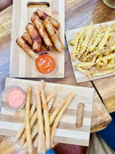a wooden table with french fries and other foods at Jezette's Inn in Sipalay