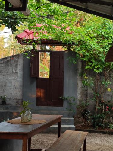 a wooden table and bench in front of a building at Tamarind Villa in Varkala
