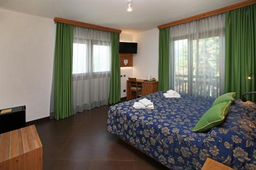 a hotel room with a bed and green curtains at Chalet ALLEMAND in Sauze dʼOulx