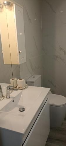 a white bathroom with a sink and a toilet at Casa de Férias Terra e Mar in Póvoa de Varzim