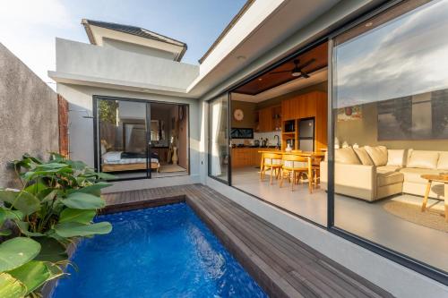 an indoor swimming pool in a house with a living room at Villa Sattvika in Kerobokan