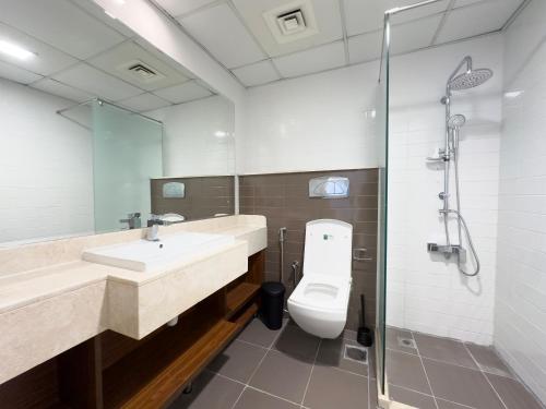 a bathroom with a toilet and a sink and a shower at 1Bedroom Apartment with Stunning Partial Sea View Pacific Al Marjan in Ras al Khaimah