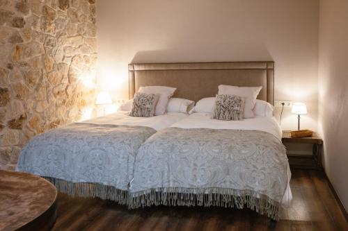 a bedroom with a large white bed with pillows at Ecohotel NÓS 