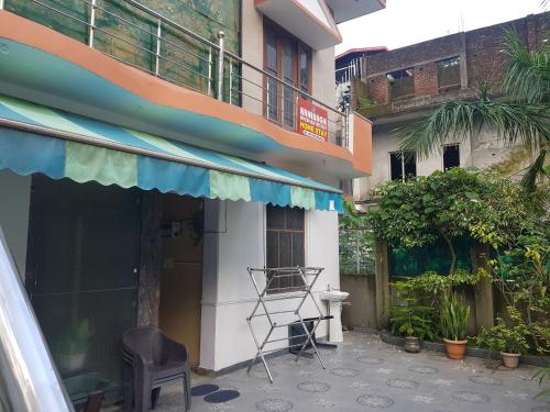 a chair sitting outside of a building with a balcony at Ranibagh Riverview Retreat in Kāthgodām