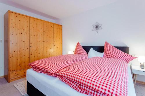 a bedroom with a bed with red and white checked pillows at Haus ANNELIES Top 3 by Moni-care in Seefeld in Tirol