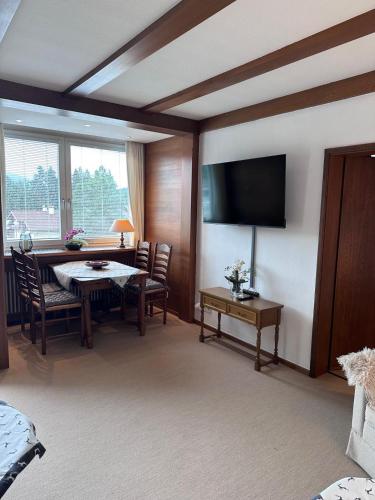a living room with a table and a television at Appartement ALEXANDRA by MoniCare in Seefeld in Tirol