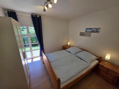 a bedroom with a bed and a large window at Gundis Heidehuus, Ferienhaus in Schneverdingen