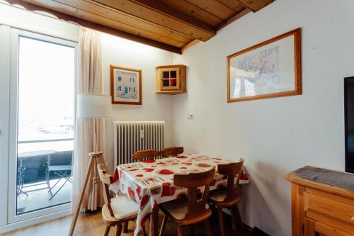 a dining room with a table and chairs and a window at Alpenstadel mit Hallenbad und Sauna by MoniCare in Seefeld in Tirol