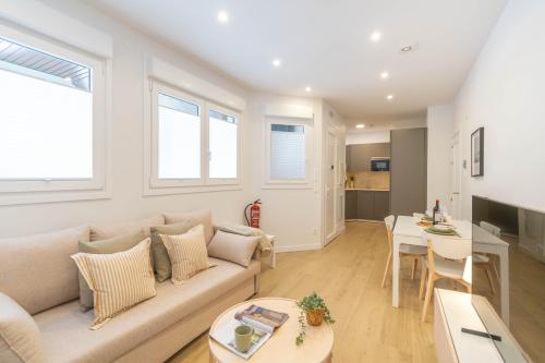 a living room with a couch and a table at Acogedor Loft a 15 minutos del centro de Pamplona in Pamplona