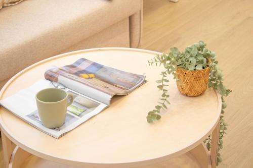 a table with a coffee cup and a plant on it at Acogedor Loft a 15 minutos del centro de Pamplona in Pamplona