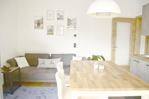 a living room with a table and a couch at Appartement ALPINOVA by MoniCare in Reith bei Seefeld