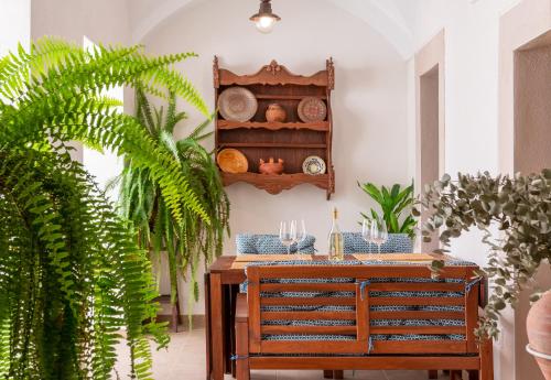 a dining room with a table with glasses and plants at Apartamentos Plaza Mayor 35 in Cáceres