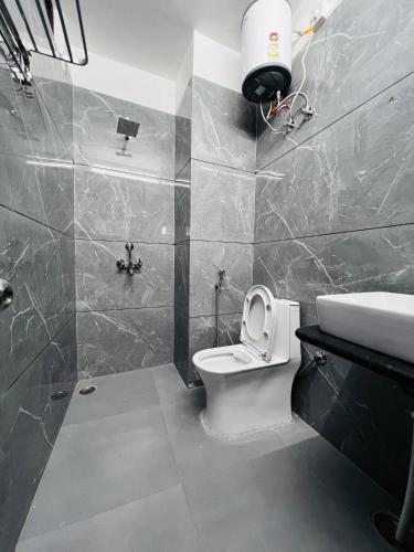 a bathroom with a toilet and a sink at White Poppy Lake Side Hostel in Udaipur