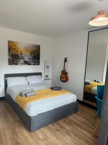 a bedroom with a bed and a guitar on the wall at Modern Spacious Crawley Studio in Crawley