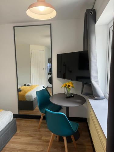 a room with a table and chairs and a mirror at Modern Spacious Crawley Studio in Crawley