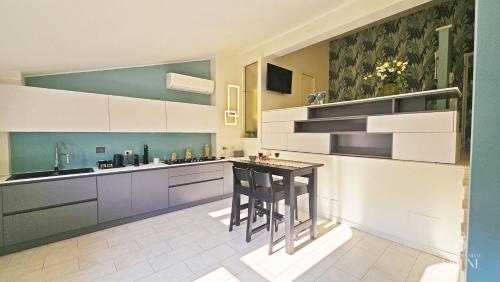 a kitchen with white cabinets and a island with stools at La Dimora delle Sirene in Tivoli