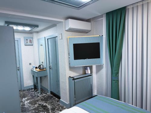 a hospital room with a tv and a bed at Santa Rio Gold Taxim Hotel in Istanbul