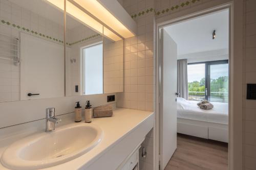 ein Badezimmer mit Waschbecken und Spiegel in der Unterkunft Appartement met 3 slaapkamers, terras en prachtig uitzicht in Knokke-Heist