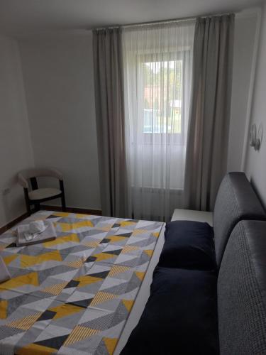a bedroom with a bed and a couch and a window at Vila Pogled in Novi Sad