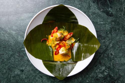 a plate of food on top of a green leaf at La Mansion Vi Vadi Hotel in Munich