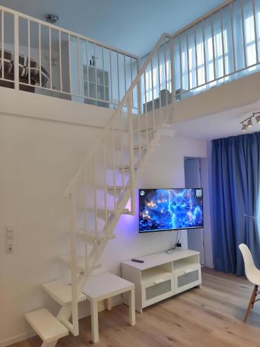 a living room with a staircase and a tv at Nahe Airport Ber Maisonettewohnung in Schönefeld