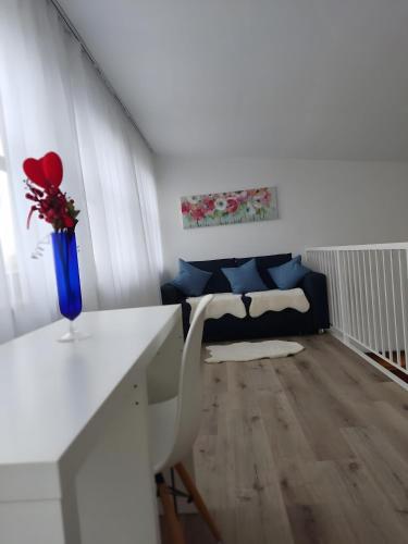 a living room with a white table and a couch at Nahe Airport Ber Maisonettewohnung in Schönefeld
