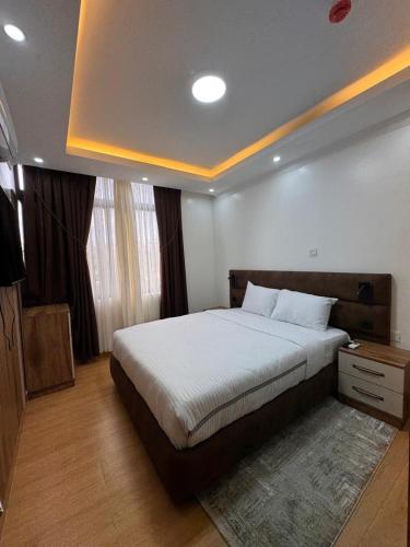 a bedroom with a large bed in a room at Cascadia Apartments Kigali in Kigali