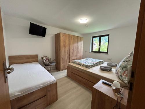 a bedroom with a bed and a tv on the wall at Allgäu Moments Oberstaufen in Oberstaufen