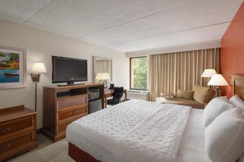 a hotel room with a bed and a flat screen tv at Long Creek Hotel in South Portland