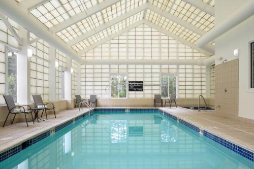 une grande piscine avec un plafond de verre dans l'établissement Long Creek Hotel, à South Portland