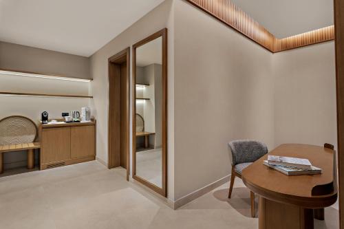 a room with a table and a mirror at Mercure Abu Dhabi Downtown in Abu Dhabi
