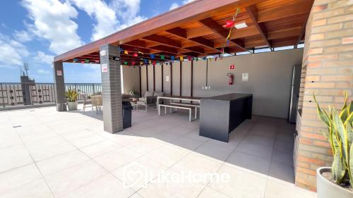 a patio with a table and benches on a roof at Edifício Mindset - LikeHome Hospedagens in João Pessoa