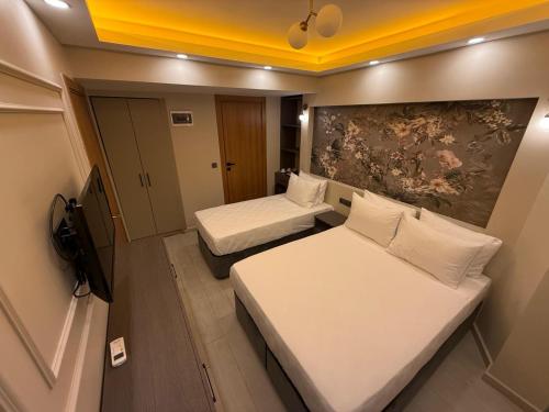 a small room with two beds and a tv at City Hotel İstanbul in Istanbul