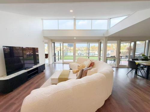 a living room with a white couch and a tv at 6-Bed Lake Escape for Families & Friends in Patterson Lakes