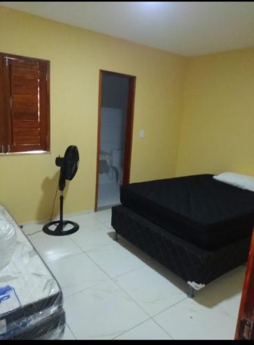 a bedroom with a bed and a fan in a room at André Safadão Turismo in Beberibe