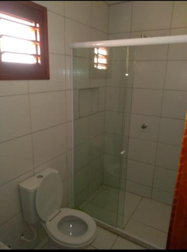 a bathroom with a toilet and a glass shower at André Safadão Turismo in Beberibe